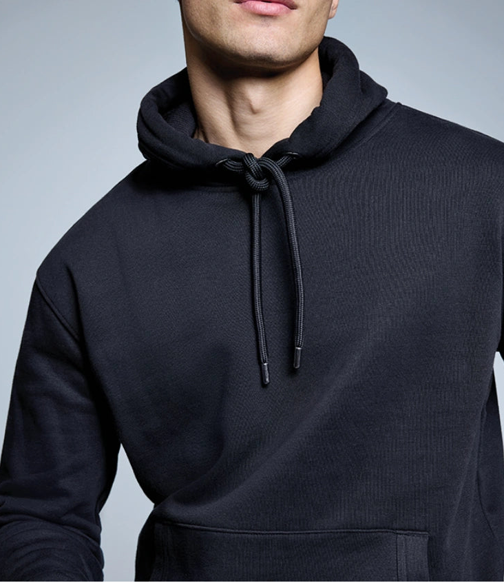 Man wearing a black hoodie against a gray background