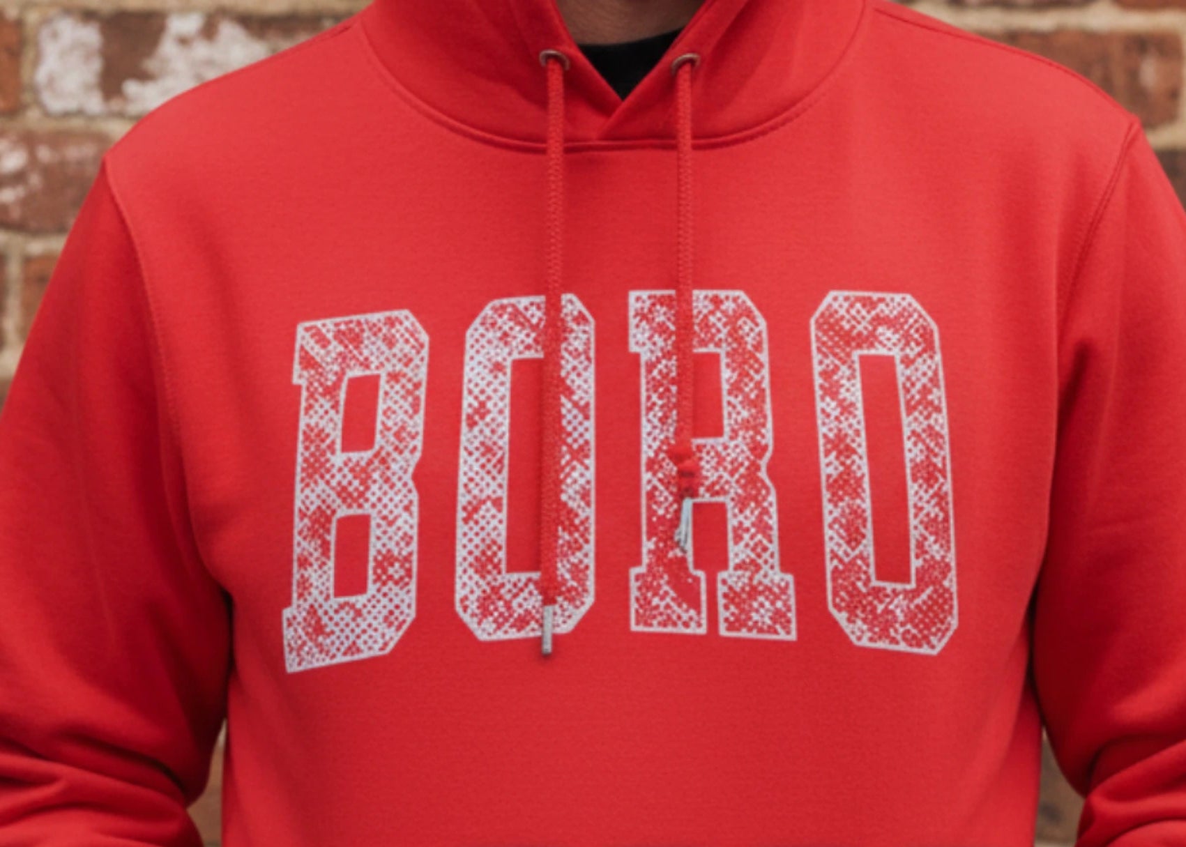 Red hoodie with 'BOHO' text, displayed against a brick wall, featuring the brand 'Fanominal'.