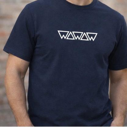 Man wearing a navy blue t-shirt with a logo against a brick wall.